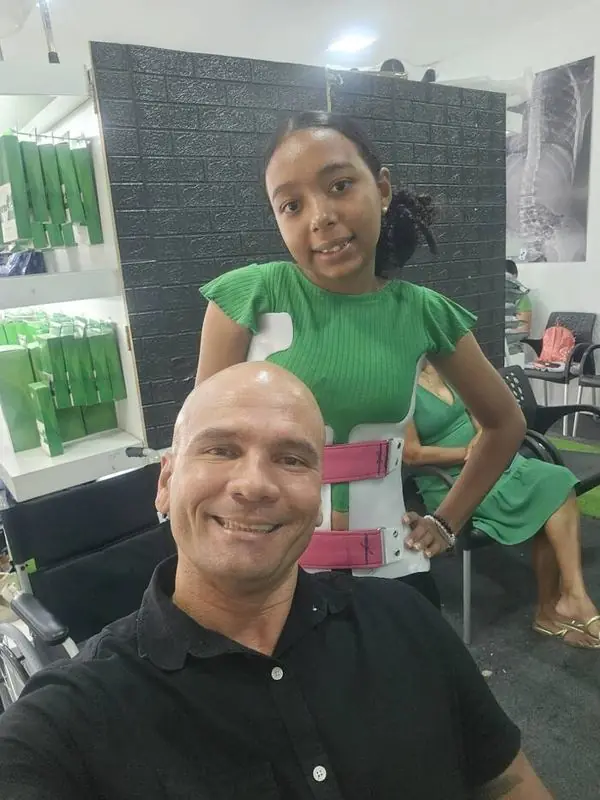 Léo com uma paciente sorrindo usando o colete