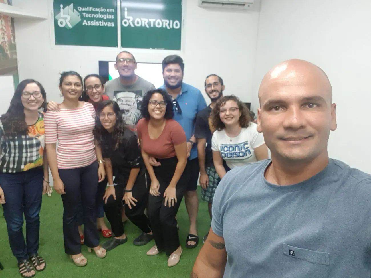 Turma da Qualificação em Tecnologias Assistivas em frente ao painel da Escola e do Ortorio