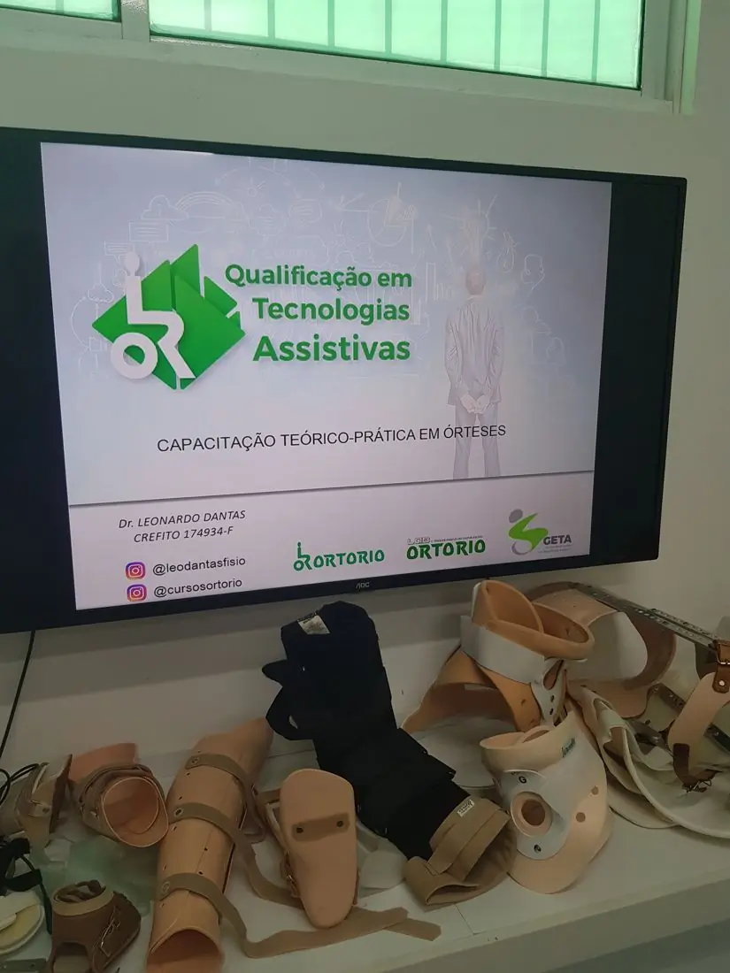 Abertura da Capacitação Teórico-Prática em Órteses, com órteses sobre a mesa da sala de aula
