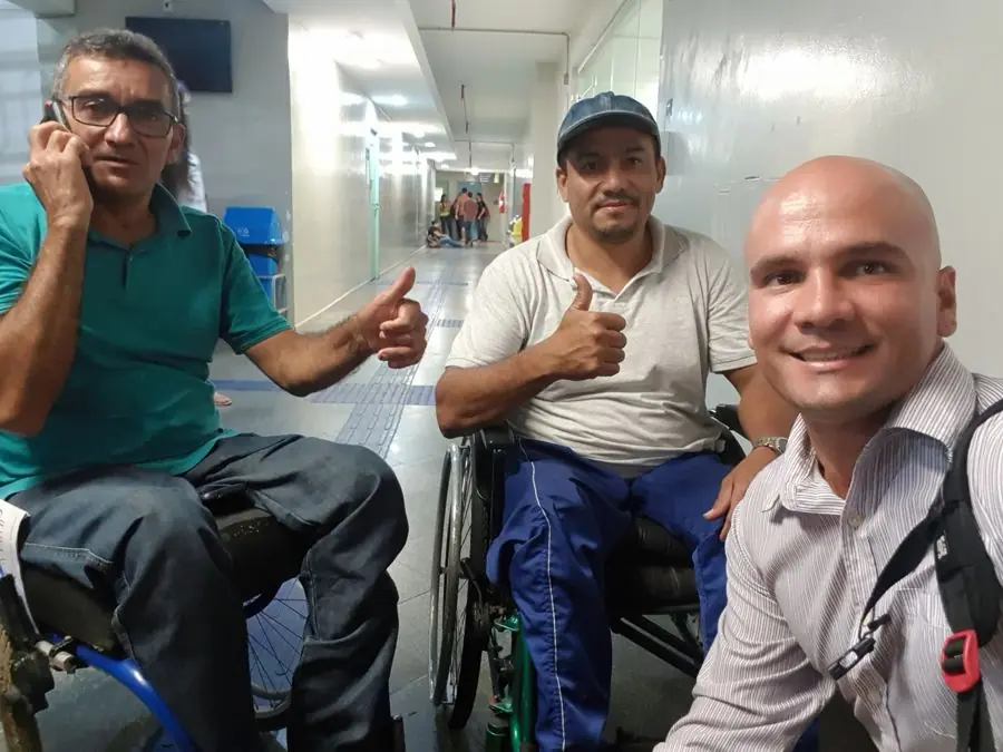 Léo com um paciente em cadeira de rodas durante aula prática