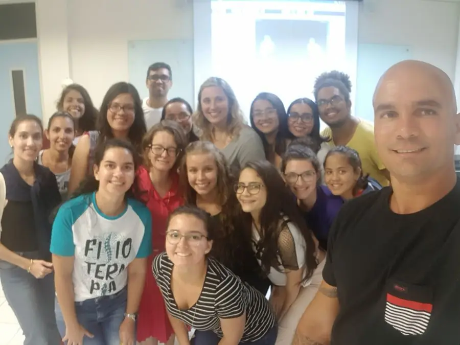 Turma de alunas de fisioterapia sorrindo em sala