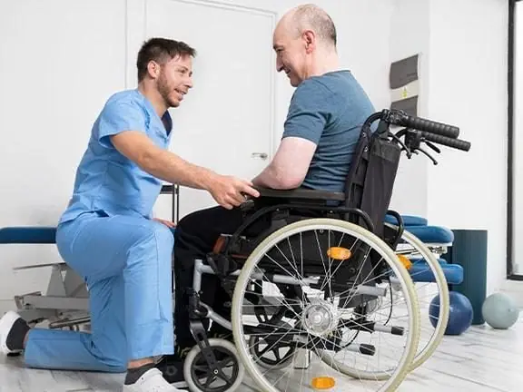 Fisioterapeuta orientando um paciente sentado na cadeira de rodas